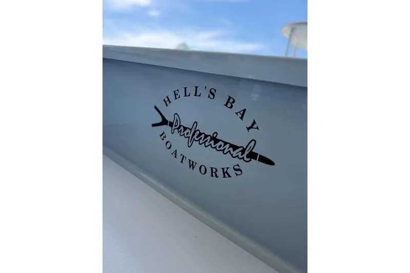Slide: The Image of 2020 Hells Bay Professional boat logo on sleek gray surface. - 1