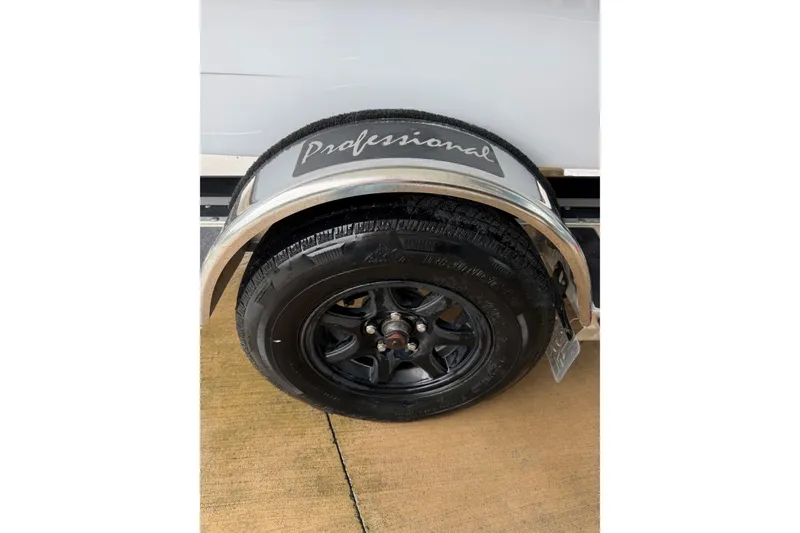 Slide: The Image of 2020 Hells Bay Professional trailer wheel with black tire and silver fender. - 6
