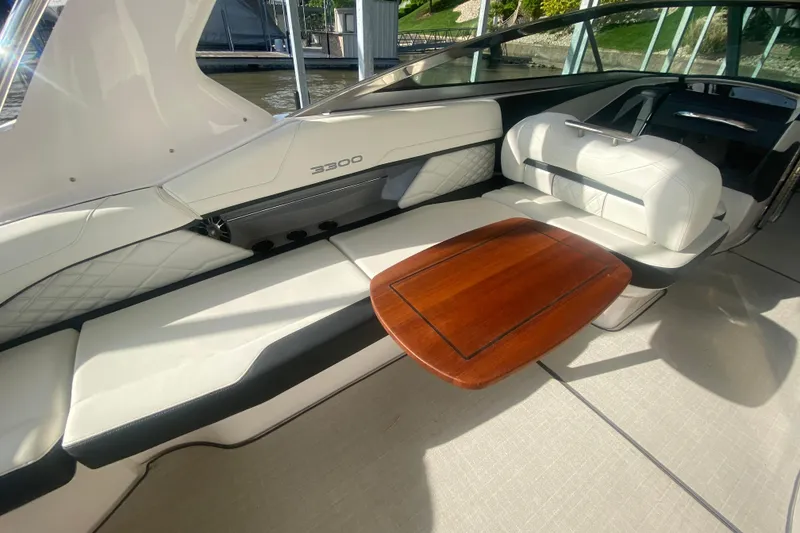 Slide: The Image of 2021 Regal 3300 Bowrider interior with white seating and wooden table. - 12