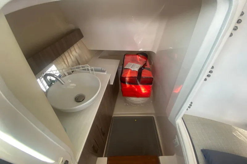 Slide: The Image of 2021 Regal 3300 Bowrider interior with sink and storage area. - 18