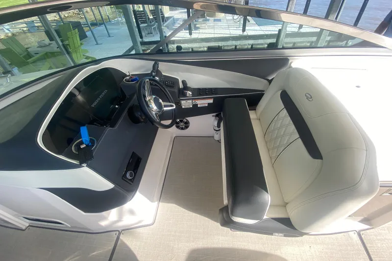 Slide: The Image of 2021 Regal 3300 Bowrider cockpit with steering wheel and cushioned seating. - 21
