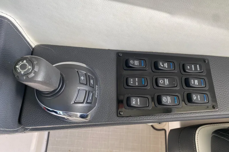 Slide: The Image of Control panel of a 2021 Regal 3300 Bowrider boat with joystick and switches. - 22
