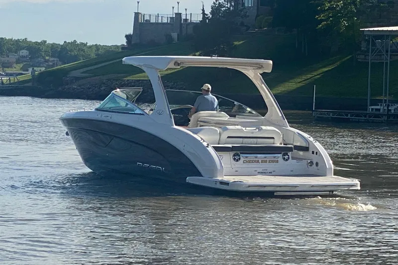 Slide: The Image of 2021 Regal 3300 Bowrider cruising on a scenic lake near a shoreline. - 3