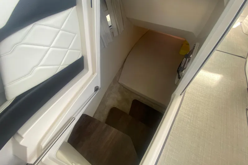 Slide: The Image of Interior cabin view of 2021 Regal 3300 Bowrider boat, featuring seating and steps. - 34