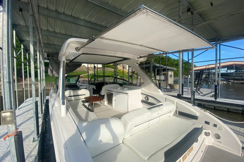 Slide: The Image of 2021 Regal 3300 Bowrider docked, featuring spacious seating and sleek design under a canopy. - 38
