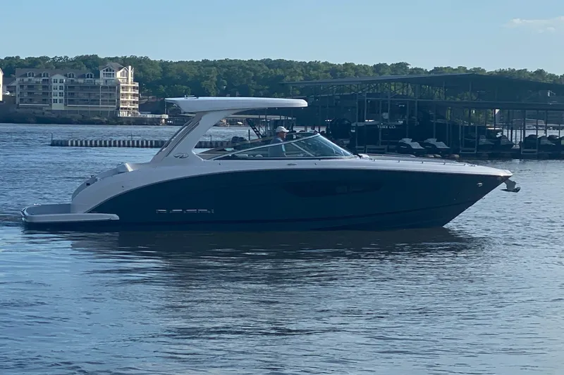 Slide: The Image of 2021 Regal 3300 Bowrider boat on calm water near marina and buildings. - 4