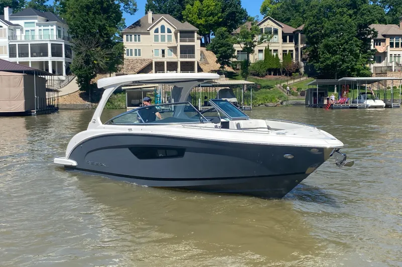 Slide: The Image of 2021 Regal 3300 Bowrider boat cruising on a calm lake near a dock. - 43