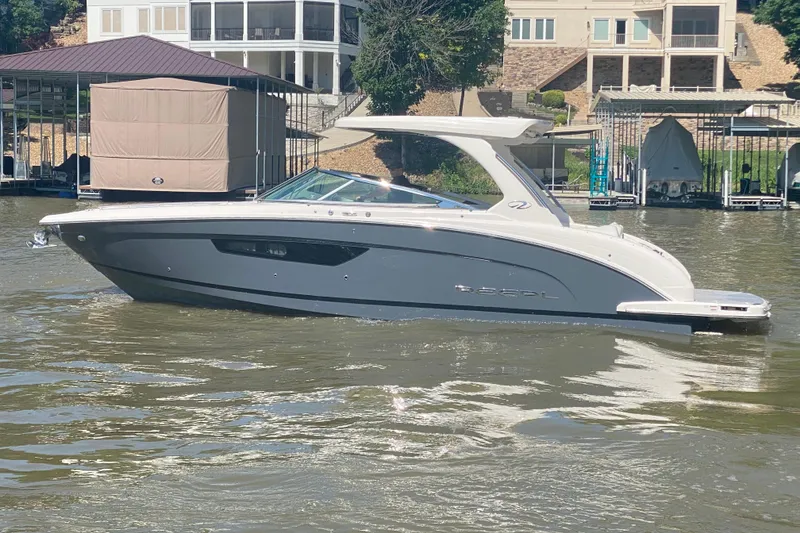 Slide: The Image of 2021 Regal 3300 Bowrider cruising on a calm lake near a dock. - 46