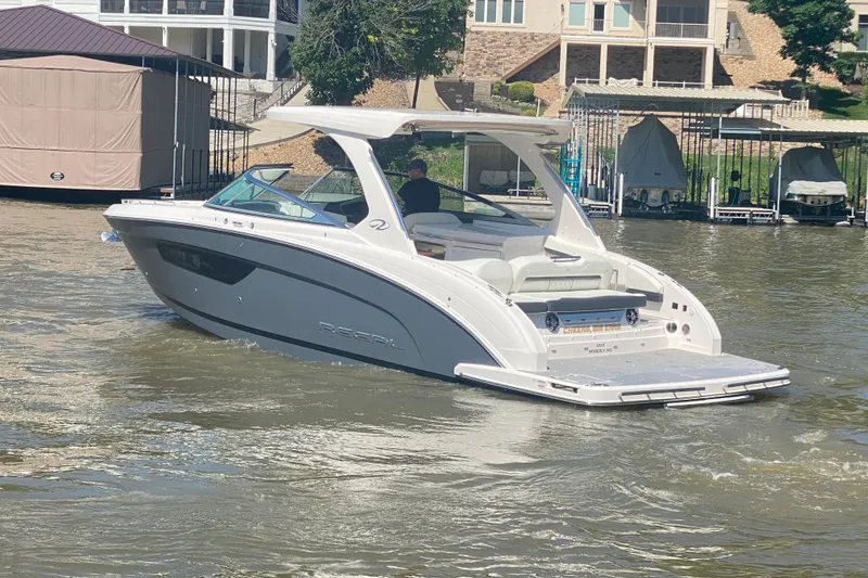 Slide: The Image of 2021 Regal 3300 Bowrider cruising on a scenic lake with a driver. - 47