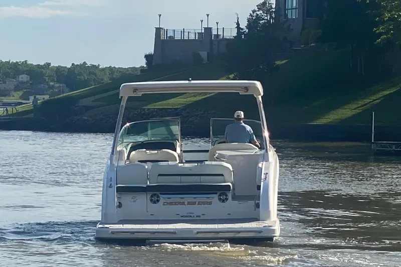Slide: The Image of 2021 Regal 3300 Bowrider cruising on a scenic lake with a driver. - 6