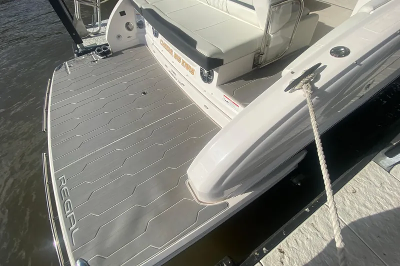 Slide: The Image of 2021 Regal 3300 Bowrider boat with spacious deck and seating, docked by water. - 7