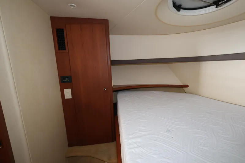 Slide: The Image of 2005 Silverton 34 Convertible yacht interior cabin with bed and wooden door. - 15