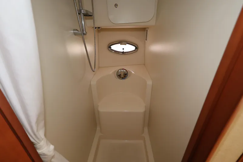 Slide: The Image of Compact shower area in 2005 Silverton 34 Convertible boat, featuring a sleek design and porthole window. - 18