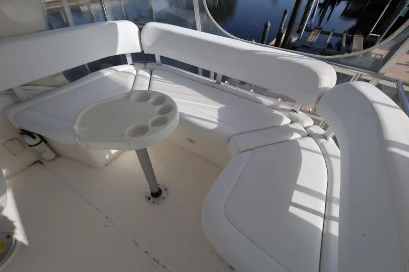 Slide: The Image of 2005 Silverton 34 Convertible yacht interior with white seating and table, dockside view. - 23