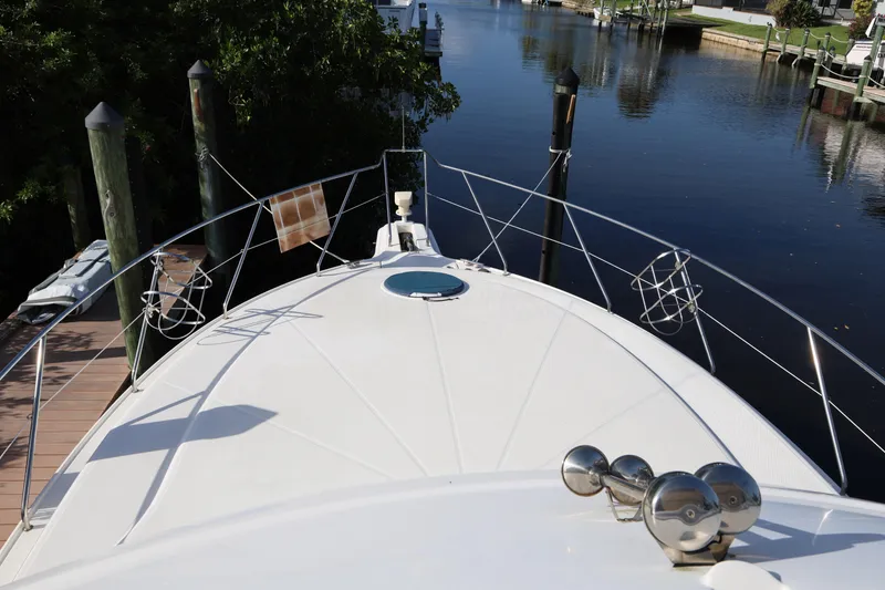 Slide: The Image of 2005 Silverton 34 Convertible yacht docked by a serene waterfront. - 26