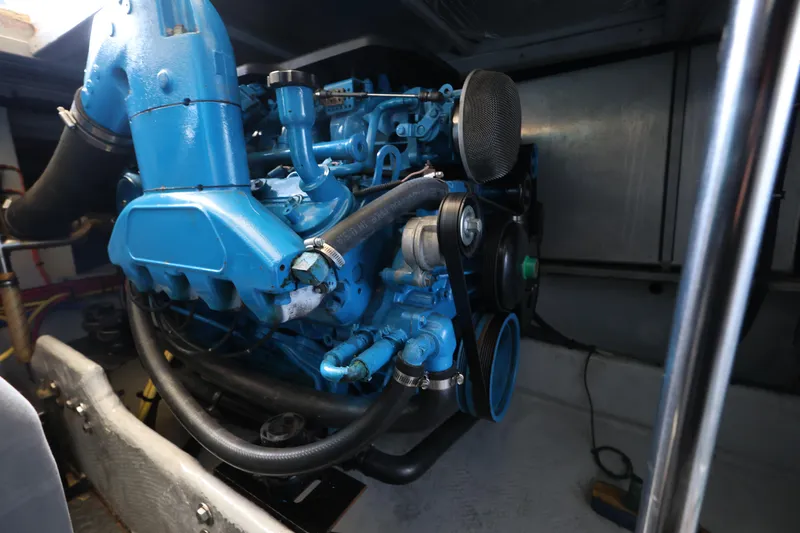 Slide: The Image of Engine room of a 2005 Silverton 34 Convertible boat, featuring a blue marine engine. - 27