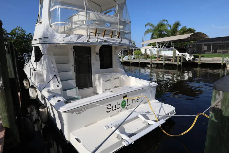 Slide: The Image of 2005 Silverton 34 Convertible yacht docked at marina, sunny day, palm trees in background. - 4