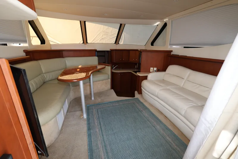 Slide: The Image of Interior of 2005 Silverton 34 Convertible yacht with sofas and a wooden table. - 7