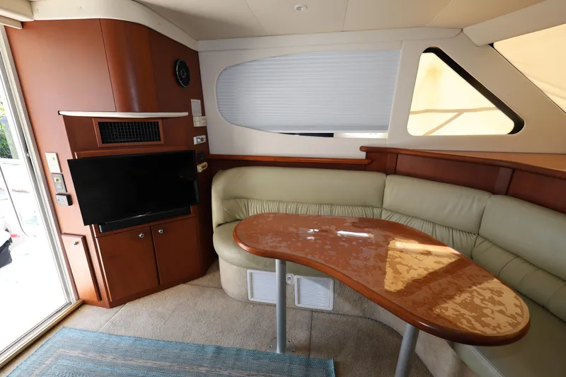 Slide: The Image of Interior of 2005 Silverton 34 Convertible yacht with TV, seating, and wooden table. - 9