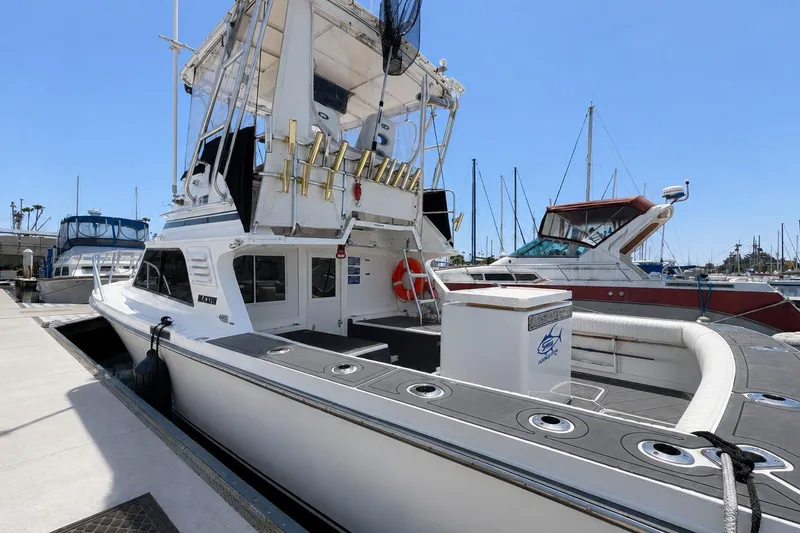 Slide: The Image of 1991 Blackfin 33 Flybridge boat docked at marina under clear blue sky. - 1