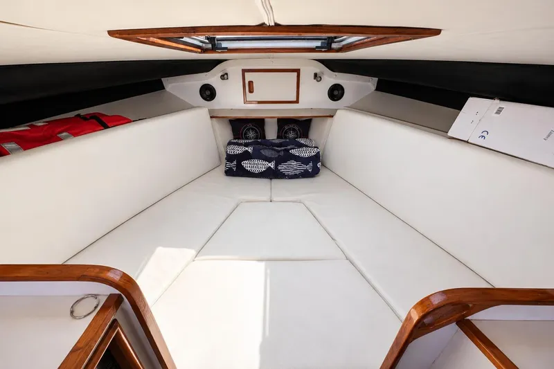 Slide: The Image of Interior cabin of 1991 Blackfin 33 Flybridge with white cushions and wooden accents. - 9