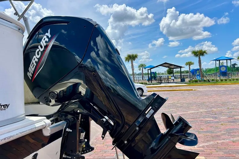 Slide: The Image of 2008 Hurricane FunDeck 226 RE with Mercury outboard motor, parked near a scenic waterfront. - 11