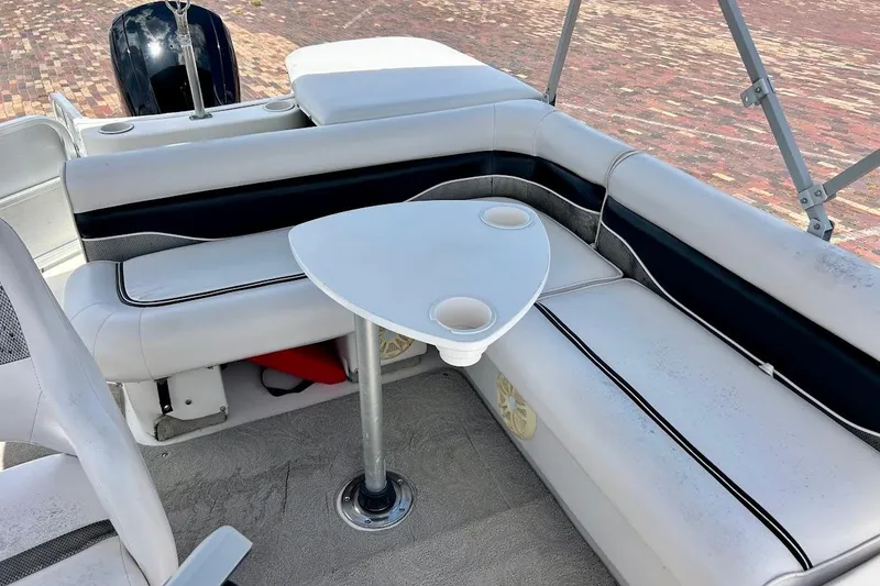 Slide: The Image of 2008 Hurricane FunDeck 226 RE boat interior with cushioned seating and a small table. - 24
