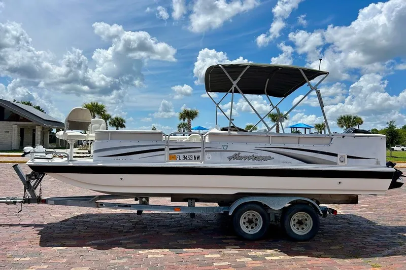 Slide: The Image of 2008 Hurricane FunDeck 226 RE boat on trailer under a sunny sky. - 3