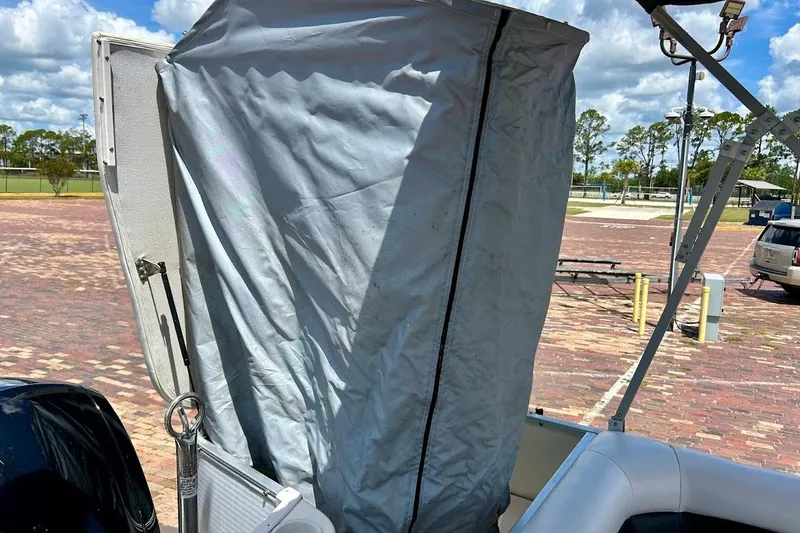 Slide: The Image of 2008 Hurricane FunDeck 226 RE boat with a covered seating area in a sunny parking lot. - 33