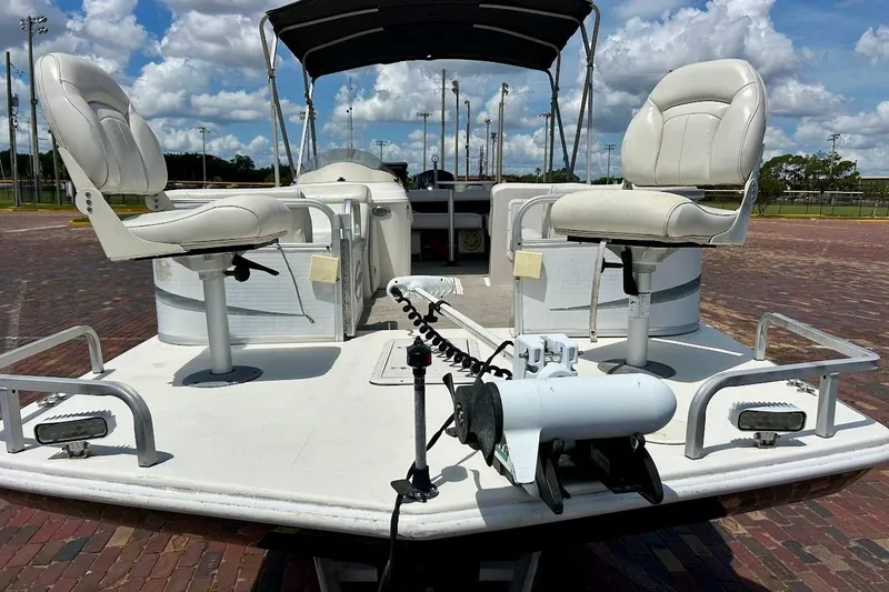 Slide: The Image of 2008 Hurricane FunDeck 226 RE boat with white seating and canopy under a blue sky. - 9