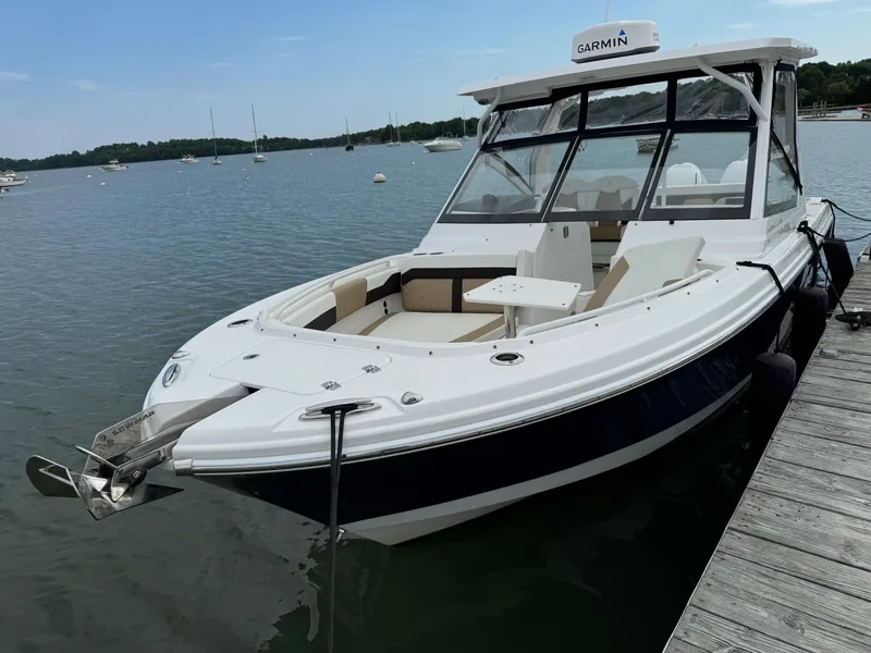 The Image of 2020 Edgewater 262 CX boat docked on a calm lake. - 0