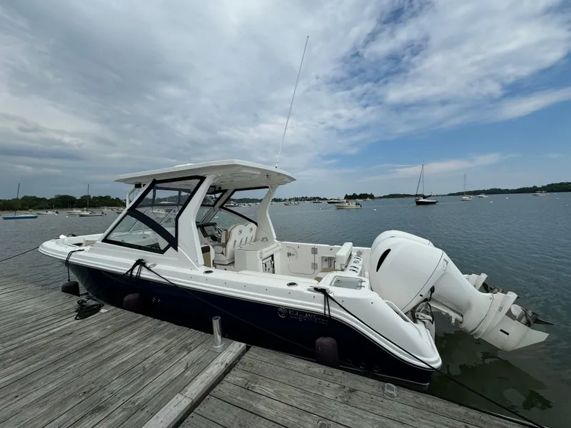 Slide: The Image of 2020 Edgewater 262 CX boat docked by the lake on a cloudy day. - 1