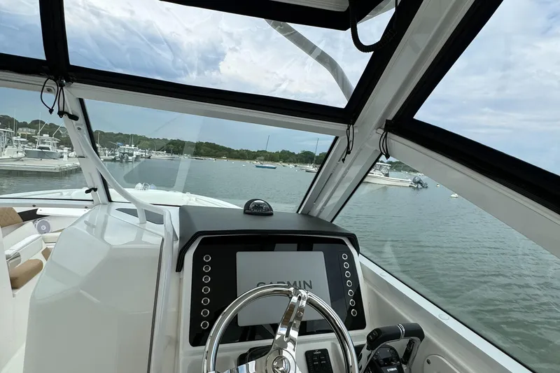 Slide: The Image of Cockpit view of a 2020 Edgewater 262 CX boat docked at a marina. - 14