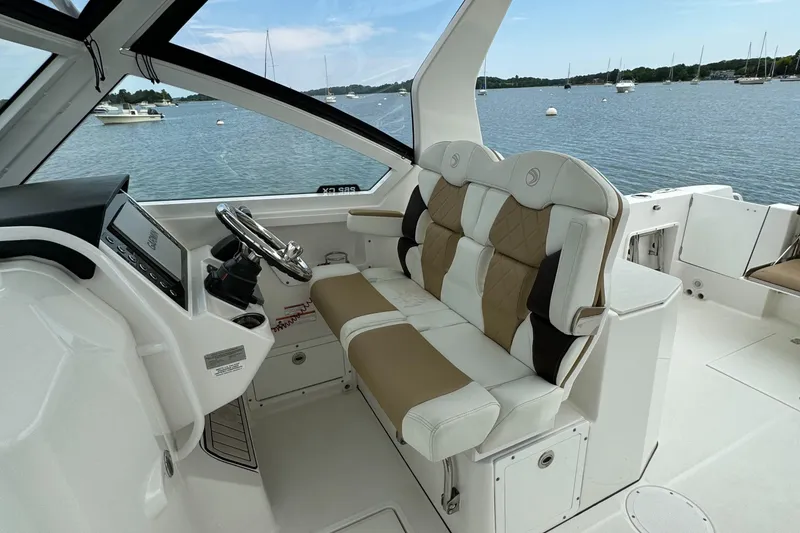 Slide: The Image of 2020 Edgewater 262 CX boat interior with dual-tone seating and steering console. - 15