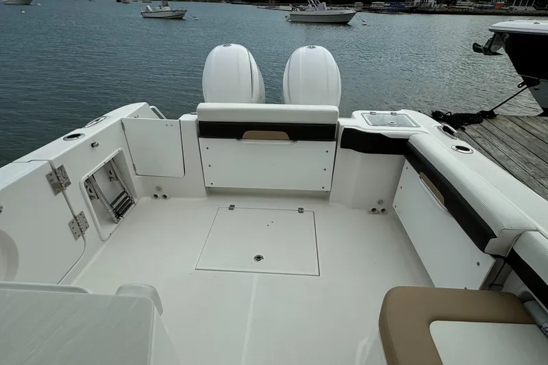 Slide: The Image of 2020 Edgewater 262 CX boat with dual outboard motors at dock. - 19