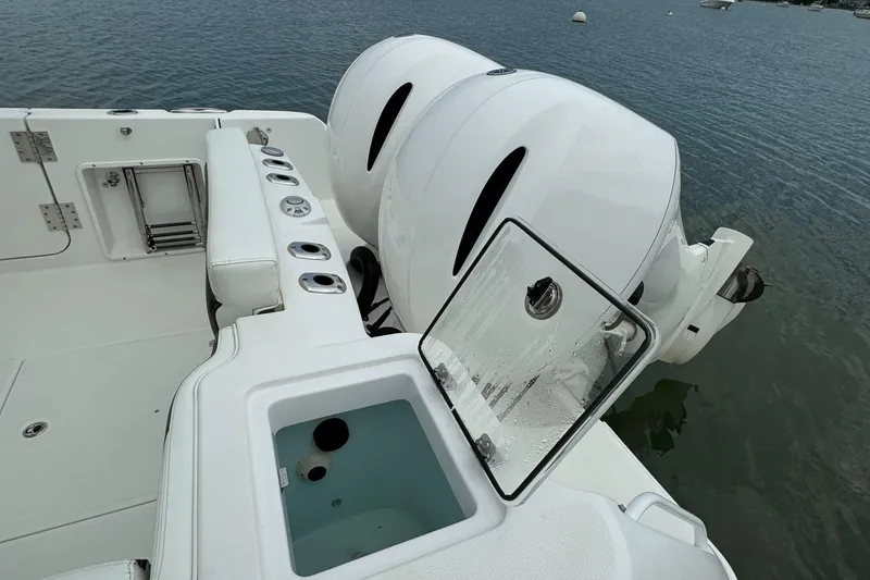 Slide: The Image of 2020 Edgewater 262 CX boat with dual outboard engines and open storage compartment. - 20