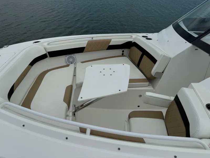 Slide: The Image of 2020 Edgewater 262 CX boat with spacious seating and table on calm water. - 4