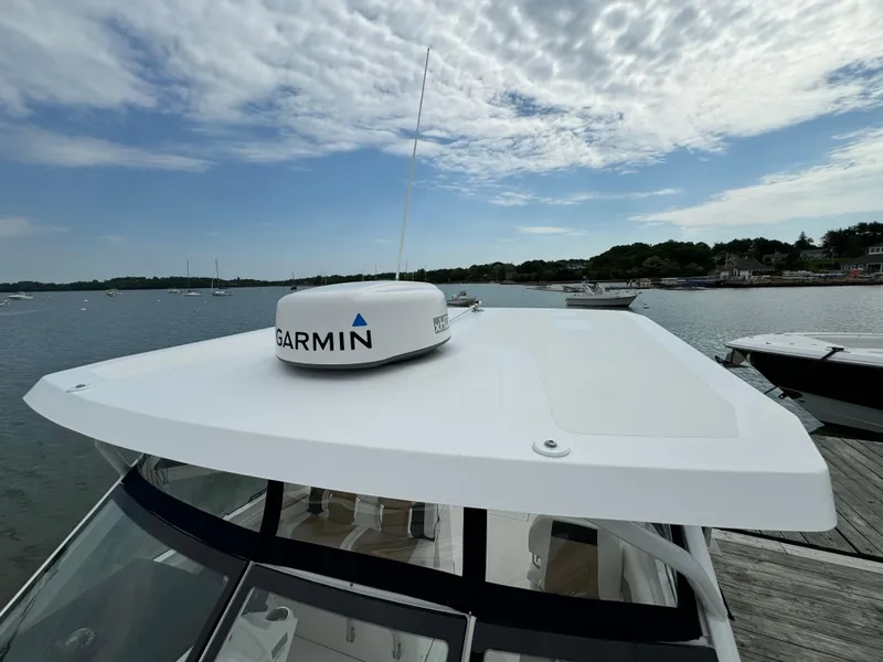 Slide: The Image of 2020 Edgewater 262 CX boat with Garmin radar on the roof, docked by the water. - 5