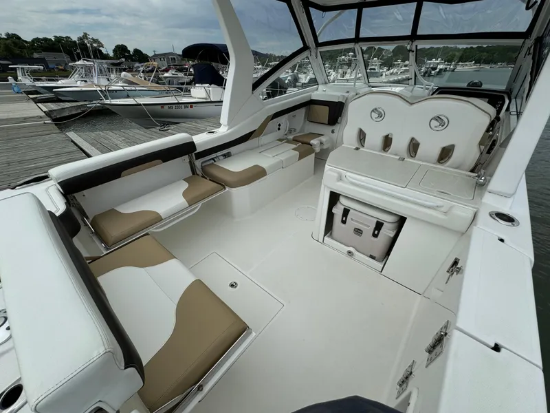 Slide: The Image of 2020 Edgewater 262 CX boat interior with seating and storage at a marina. - 8