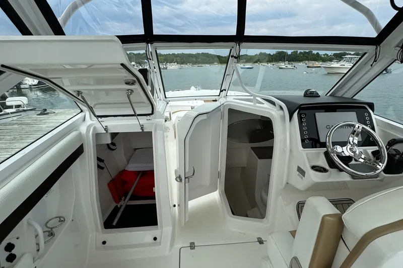 Slide: The Image of Interior of 2020 Edgewater 262 CX boat with open compartments and steering console. - 9