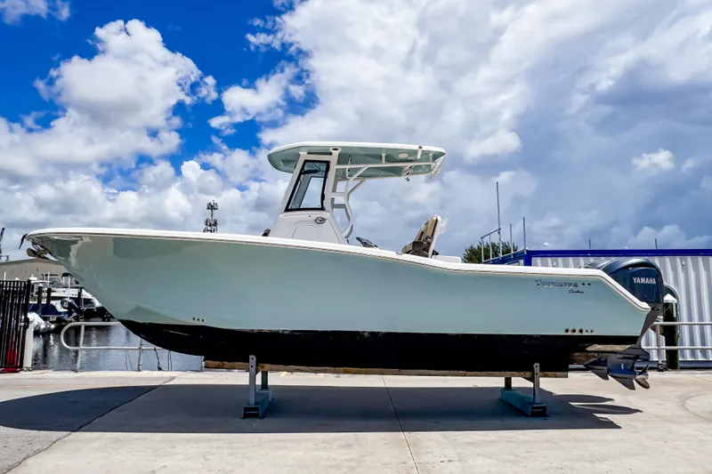 The Image of 2023 Tidewater 280 CC Adventure boat on display under a partly cloudy sky. - 0