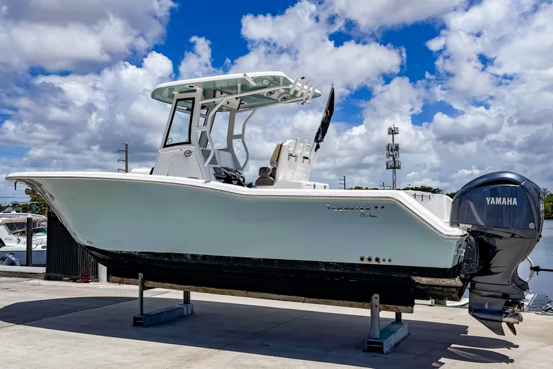 Slide: The Image of 2023 Tidewater 280 CC Adventure boat with Yamaha engine on display under a cloudy sky. - 1