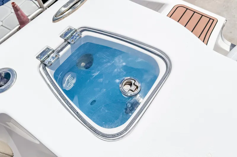 Slide: The Image of Livewell on 2023 Tidewater 280 CC Adventure boat, featuring a clear lid and secure latch. - 10