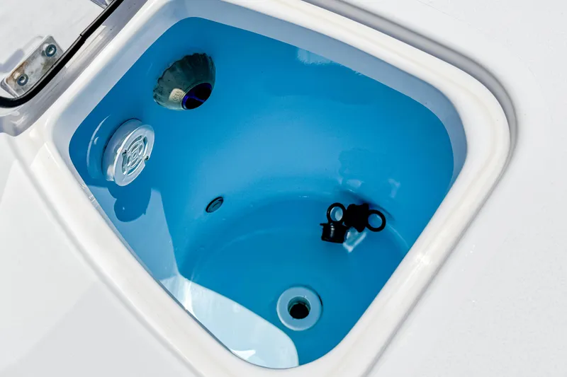Slide: The Image of Livewell compartment in 2023 Tidewater 280 CC Adventure boat, featuring blue interior. - 11
