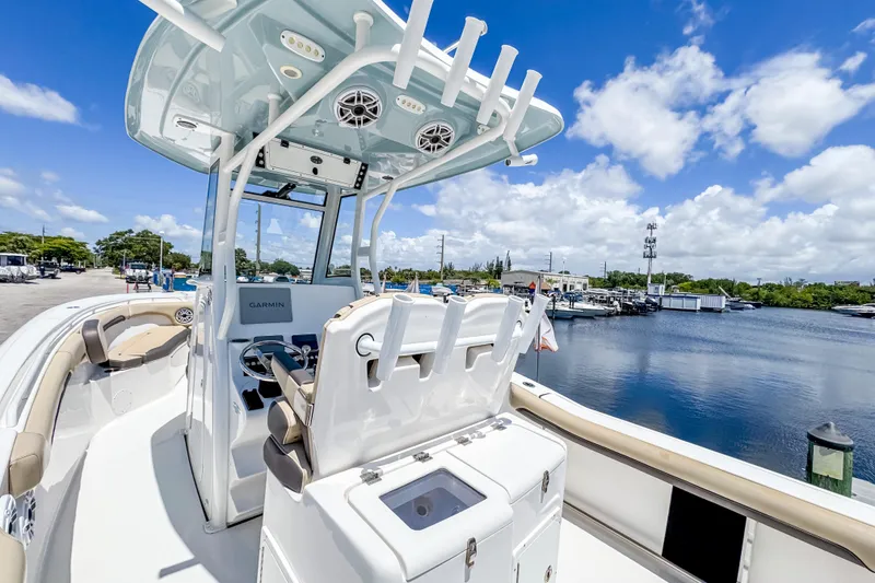 Slide: The Image of 2023 Tidewater 280 CC Adventure boat interior with helm, seating, and water view. - 12