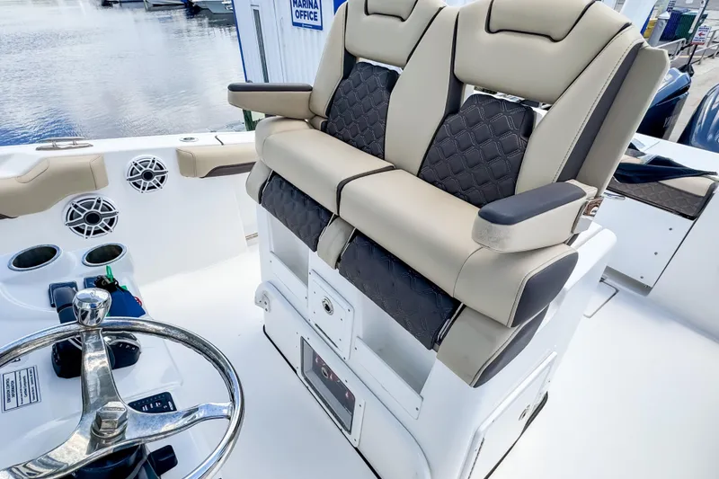 Slide: The Image of 2023 Tidewater 280 CC Adventure boat interior with luxurious seating and steering wheel. - 16