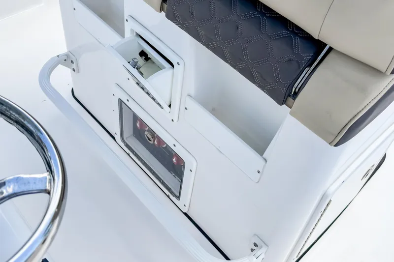 Slide: The Image of 2023 Tidewater 280 CC Adventure boat console with storage compartment and cushioned seating. - 17