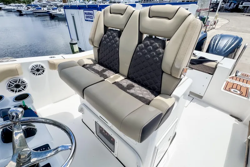 Slide: The Image of 2023 Tidewater 280 CC Adventure boat interior with luxurious seating at marina. - 18