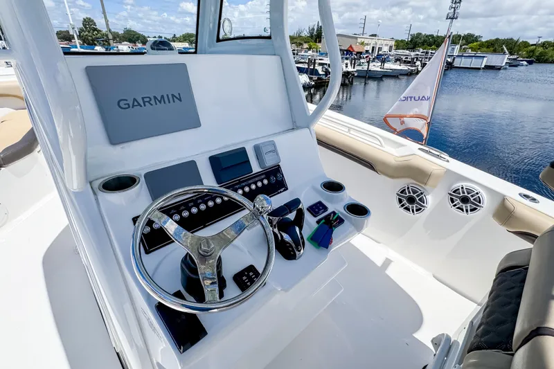 Slide: The Image of 2023 Tidewater 280 CC Adventure boat helm with Garmin display and controls. - 19