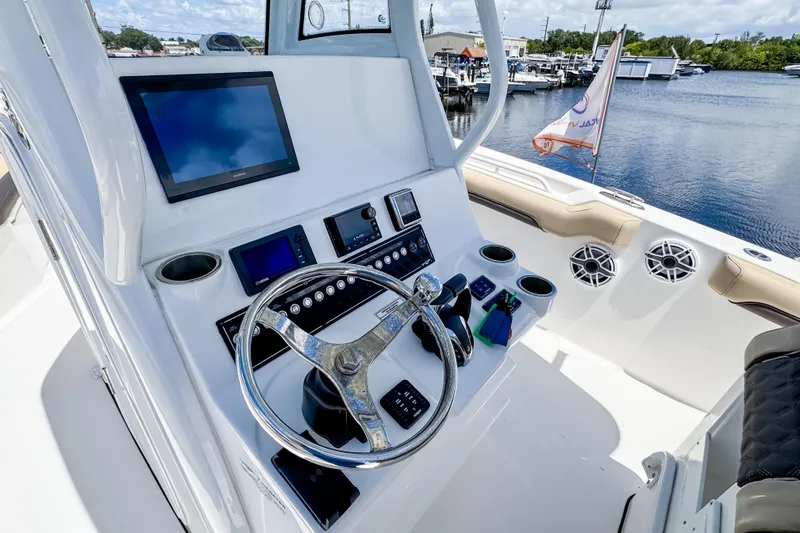 Slide: The Image of 2023 Tidewater 280 CC Adventure boat helm with modern navigation equipment and steering wheel. - 20